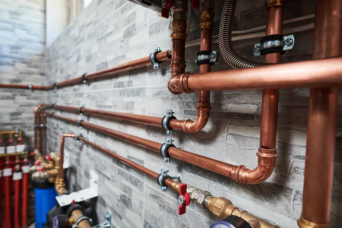 Galvanized pipe vs copper pipe comparison featuring modern copper plumbing lines and fittings in a residential plumbing system