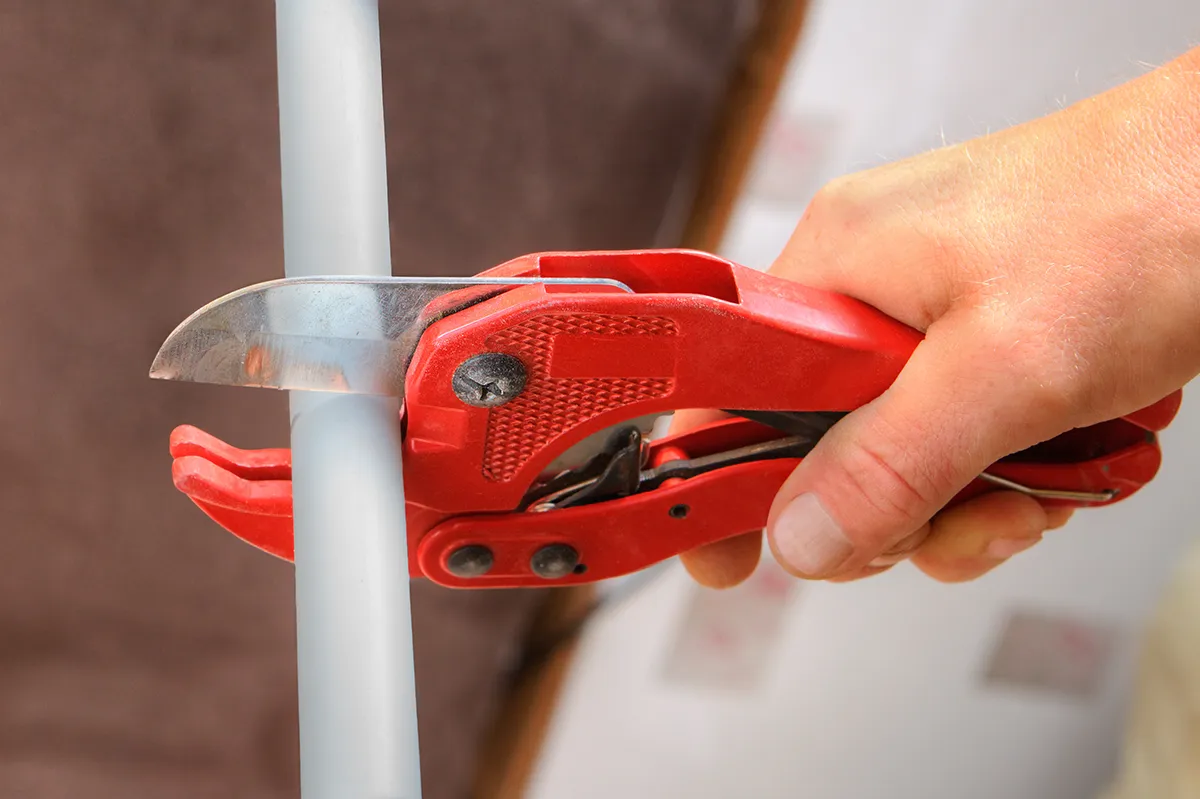 Plumber cutting polybutylene pipes during a whole-home pipe replacement