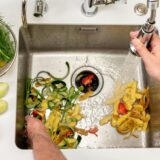 Vegetable scraps and potato peels in the kitchen sink